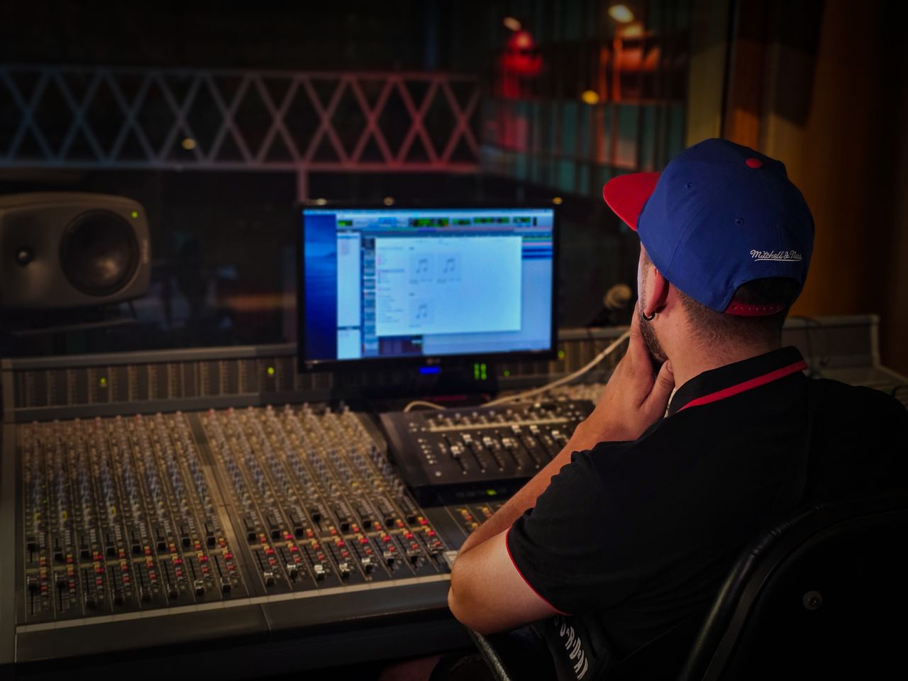 Mastering the First Impression: Your intriguing post title goes here Audio engineer working at mixing console in cozy recording studio with ambient lighting.